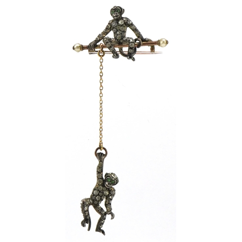 3104 - An antique silver and yellow metal brooch in the form of two monkeys, set with clear paste and green... 