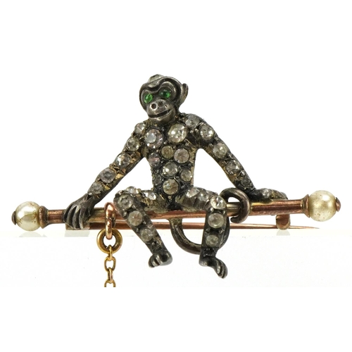 3104 - An antique silver and yellow metal brooch in the form of two monkeys, set with clear paste and green... 