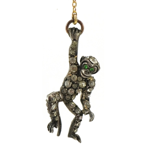 3104 - An antique silver and yellow metal brooch in the form of two monkeys, set with clear paste and green... 