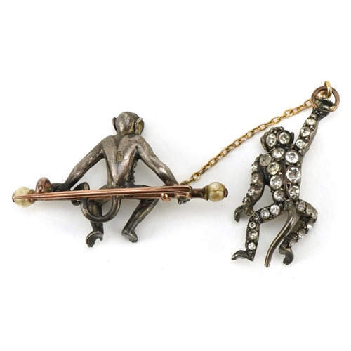 3104 - An antique silver and yellow metal brooch in the form of two monkeys, set with clear paste and green... 