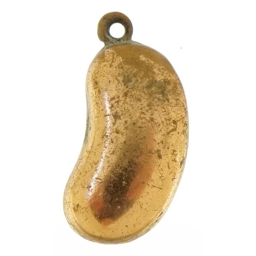 3651 - A yellow metal charm in the form of a kidney bean, 1.8cm high, 1.1g.