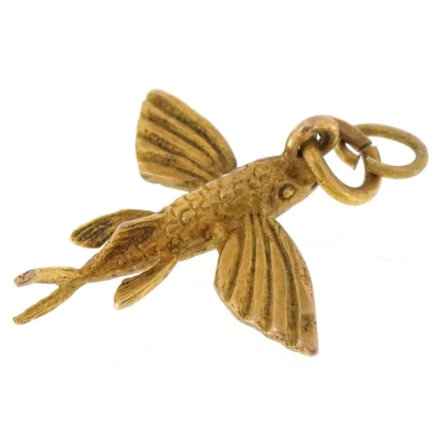 3418 - A 9ct gold charm in the form of a flying fish, 1.8cm in length, 1.4g.