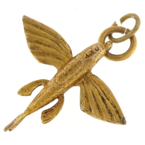 3418 - A 9ct gold charm in the form of a flying fish, 1.8cm in length, 1.4g.