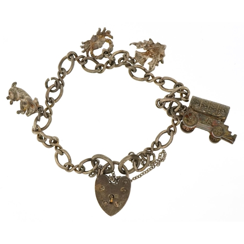 3648 - A silver charm bracelet with a collection of mostly silver charms including an opening Gypsy wagon a... 