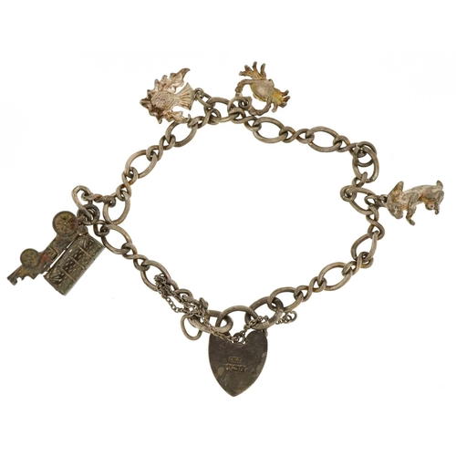 3648 - A silver charm bracelet with a collection of mostly silver charms including an opening Gypsy wagon a... 