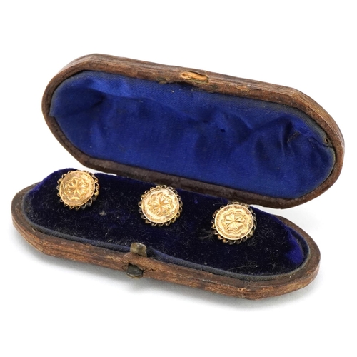 3201 - A set of three Victorian unmarked gold gentlemen's dress studs housed in a velvet and silk lined fit... 