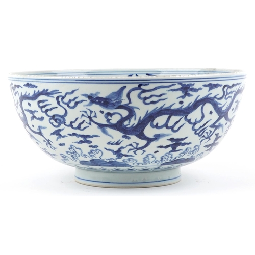 340 - A large Chinese blue and white porcelain footed bowl hand painted with dragons chasing flaming pearl... 