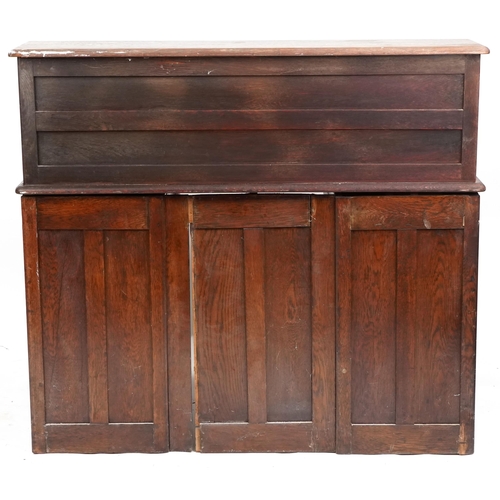 2056 - An early 20th century oak roll top desk the tambour front revealing a fitted interior above eight dr... 