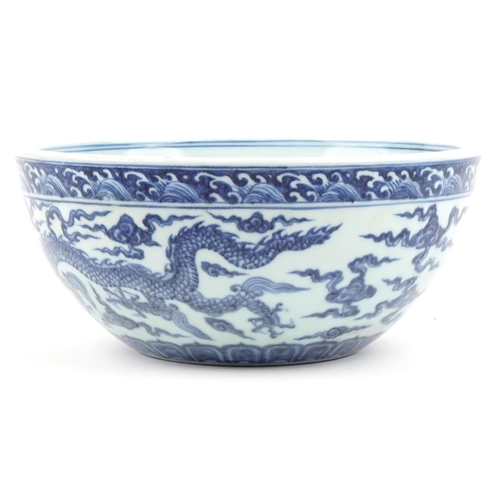 316 - A Chinese porcelain blue and white fruit bowl hand painted with dragons amongst clouds, 27cm in diam... 