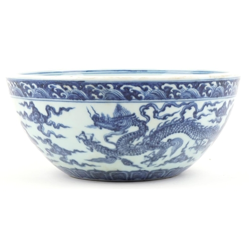 316 - A Chinese porcelain blue and white fruit bowl hand painted with dragons amongst clouds, 27cm in diam... 