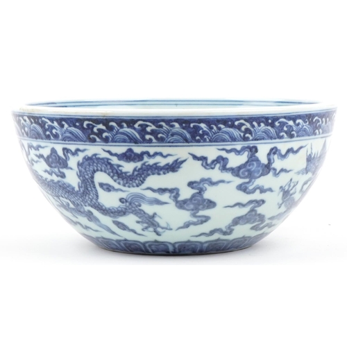 316 - A Chinese porcelain blue and white fruit bowl hand painted with dragons amongst clouds, 27cm in diam... 