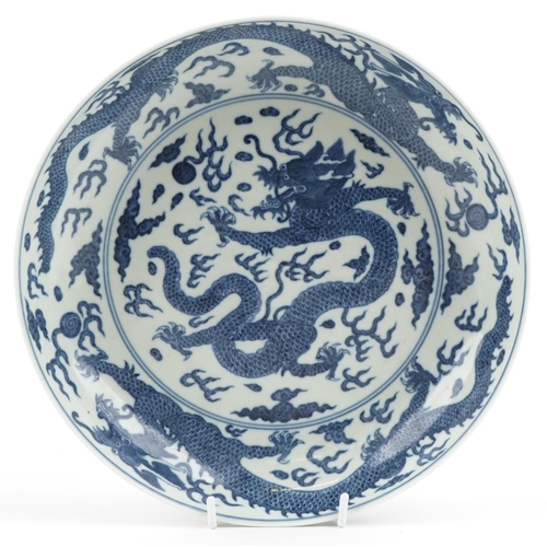 248 - A Chinese porcelain blue and white shallow bowl hand painted with a continuous band of dragons among... 