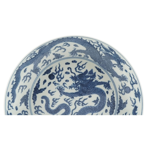 248 - A Chinese porcelain blue and white shallow bowl hand painted with a continuous band of dragons among... 