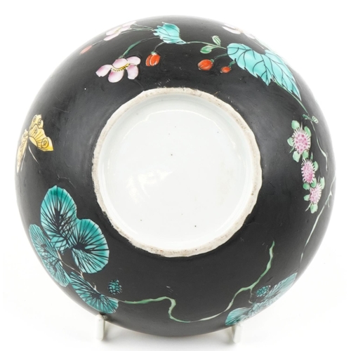 341 - A Chinese porcelain bun shaped box and cover hand painted in the famille noire palette with flowers,... 