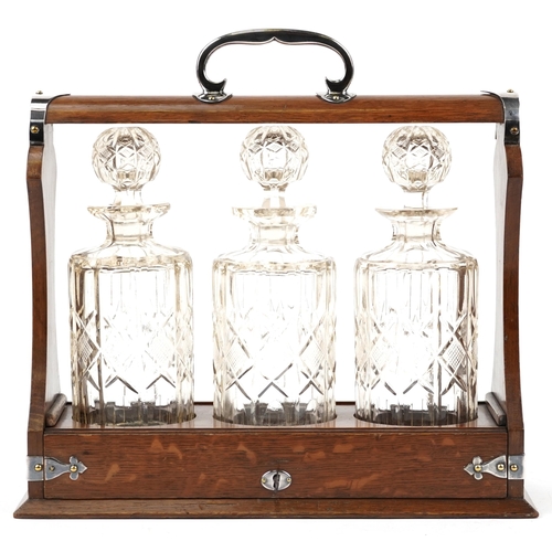 442 - An Edwardian style oak three bottle tantalus with silver plated mounts and key, 35cm wide x 34cm hig... 