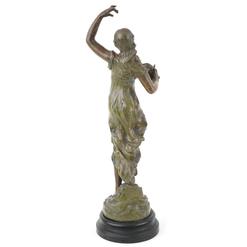 487 - After Besombes, a spelter study of an Art Nouveau female holding a script, raised on an ebonised bas... 