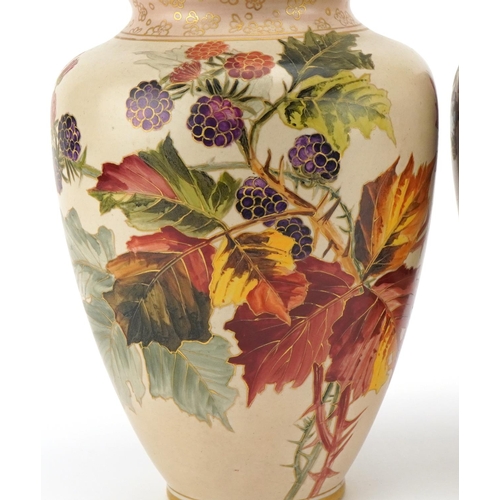 56 - A pair of Doulton Lambeth Carrara vases hand painted with autumn leaves and berries, 32cm high.