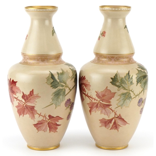 56 - A pair of Doulton Lambeth Carrara vases hand painted with autumn leaves and berries, 32cm high.