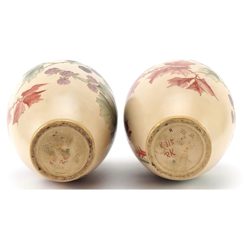 56 - A pair of Doulton Lambeth Carrara vases hand painted with autumn leaves and berries, 32cm high.