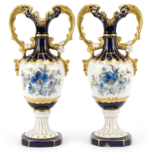 214 - A pair of Royal Dux Czechoslovakian porcelain vases with gilt twin handles and hand painted with flo... 