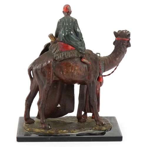 10 - A cold painted spelter table lighter in the form of an Arab carpet seller on a camel, 19cm high.