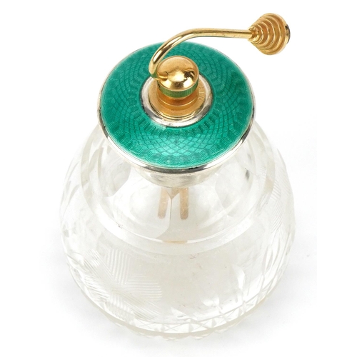 628 - An Art Deco glass atomiser with sterling silver and green guilloche enamel lid, 13cm high.