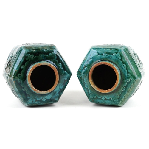 2599 - A pair of Chinese hexagonal green glazed terracotta vases, 20th century, each moulded in relief with... 