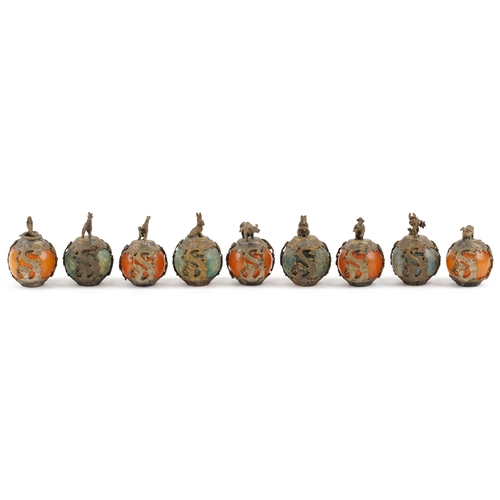 376 - A group of nine Tibetan gilt metal mounted jadeite and reconstituted amber zodiac balls, 20th centur... 