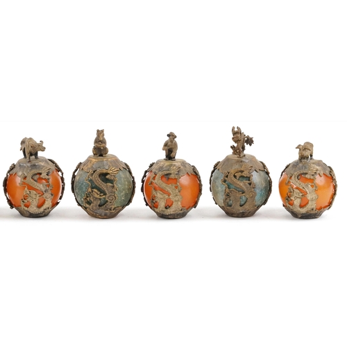 376 - A group of nine Tibetan gilt metal mounted jadeite and reconstituted amber zodiac balls, 20th centur... 