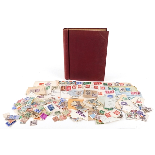 1329 - A red stamp album containing 19th century and later British and world stamps including China, France... 