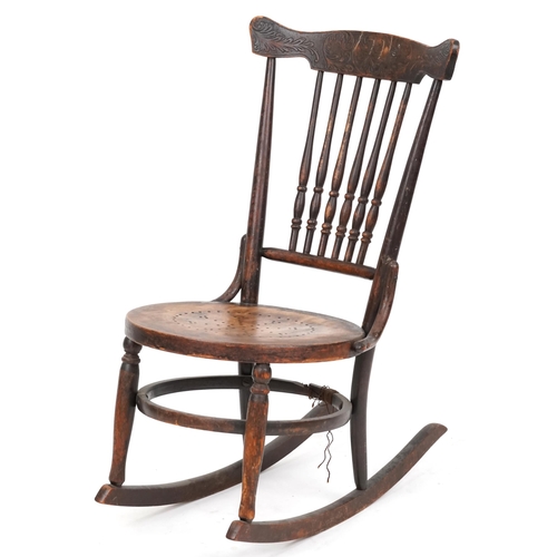 2187 - An early 20th century American carved beech rocking chair, 81cm high x 47cm wide.