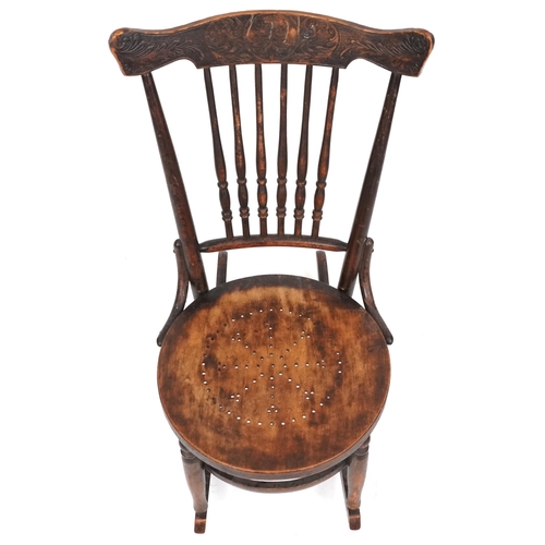 2187 - An early 20th century American carved beech rocking chair, 81cm high x 47cm wide.