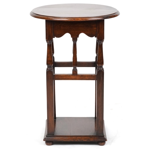 2189 - A 20th century Arts & Crafts style oak circular lamp table on turned and block supports, 75cm high x... 