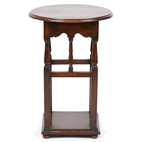 2189 - A 20th century Arts & Crafts style oak circular lamp table on turned and block supports, 75cm high x... 