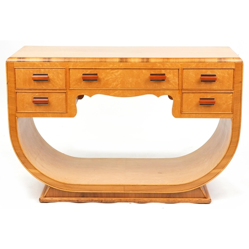 An Art Deco bird's eye maple and walnut console table of U shaped form fitted with five drawers with Bakelite handles above and open under tier, 78cm H  x 120cm W x 47cm D