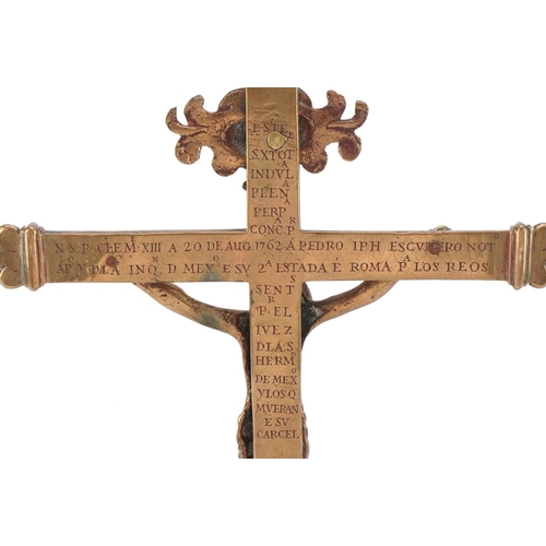 1650 - An 18th century Spanish brass crucifix circa 1762, bearing engraved script verso, 34cm x 18cm.