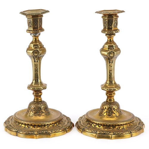 1600 - A pair of 19th century brass candlesticks with embossed scrollwork decoration and detachable sconces... 