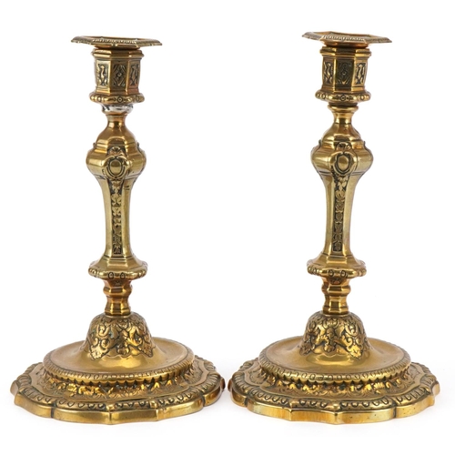 1600 - A pair of 19th century brass candlesticks with embossed scrollwork decoration and detachable sconces... 