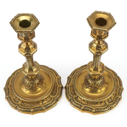 1600 - A pair of 19th century brass candlesticks with embossed scrollwork decoration and detachable sconces... 