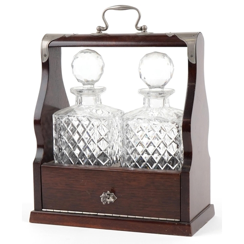 1618 - A 20th century mahogany cased two bottle tantalus, the decanters with cut glass decoration, with key... 