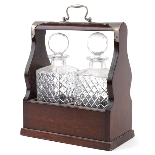 1618 - A 20th century mahogany cased two bottle tantalus, the decanters with cut glass decoration, with key... 