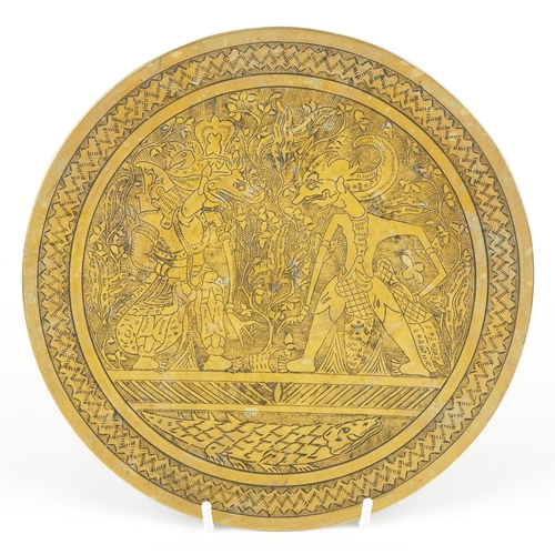 410 - An Indian bronze plate engraved with mythical figures, 23.5cm in diameter.