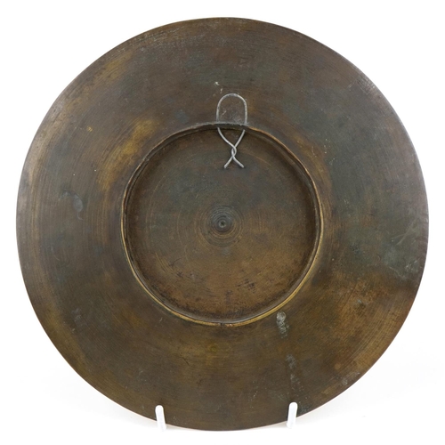 410 - An Indian bronze plate engraved with mythical figures, 23.5cm in diameter.