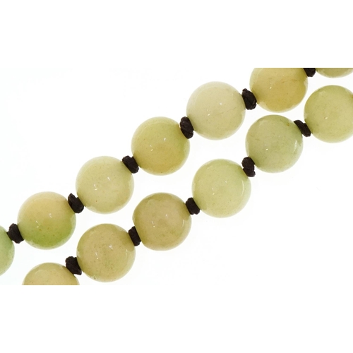 3439 - A Chinese pale green jade bead necklace, each bead 10mm in diameter, 124cm in length, total 153.0g.