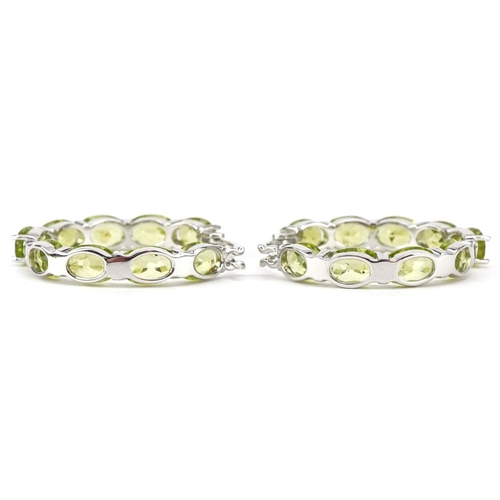 3140 - A pair of silver peridot hoop earrings, total  peridot weight approximately 15 carat, 30mm in diamet... 