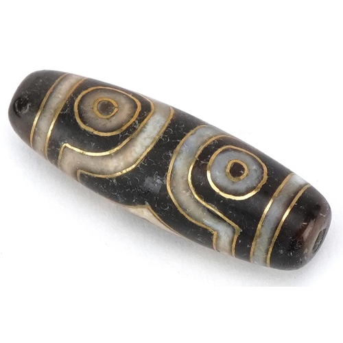 392 - An Islamic agate bead with yellow metal inlay, 3.5cm in length, 8.8g.