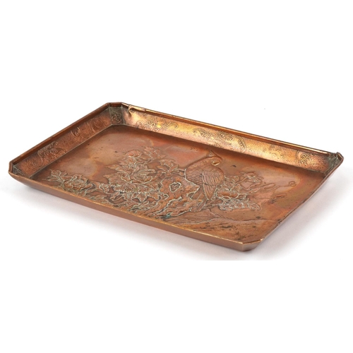 523 - A Chinese coppered tray decorated in relief with a bird of paradise amongst flowers, character marks... 