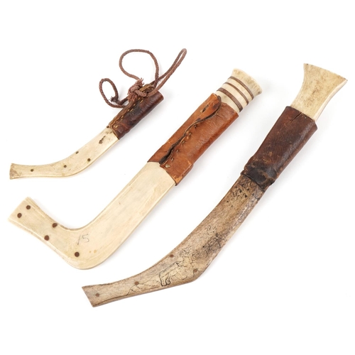 132 - Three Finnish hand carved bone knives with sheaths, the largest 27cm in length.