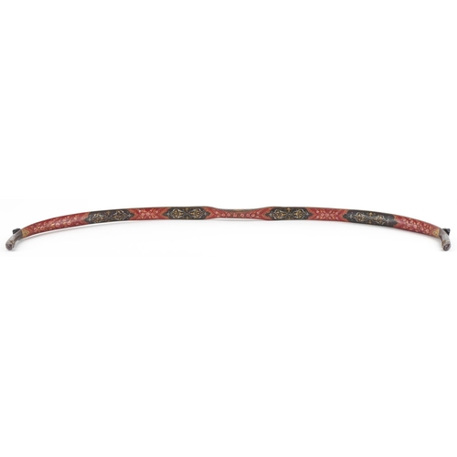 384 - A Turkish Ottoman fighting bow hand painted and gilded with flowers, 88cm in length.