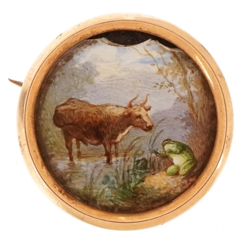 3014 - A yellow metal and enamel brooch hand painted with a cow and frog, 2.2cm in diameter, 5.4g.